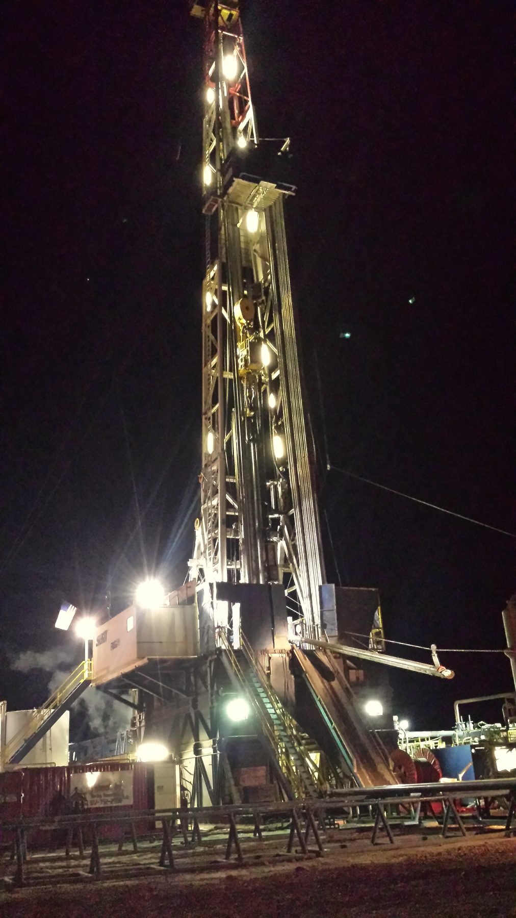 A drilling rig lit up and running at night