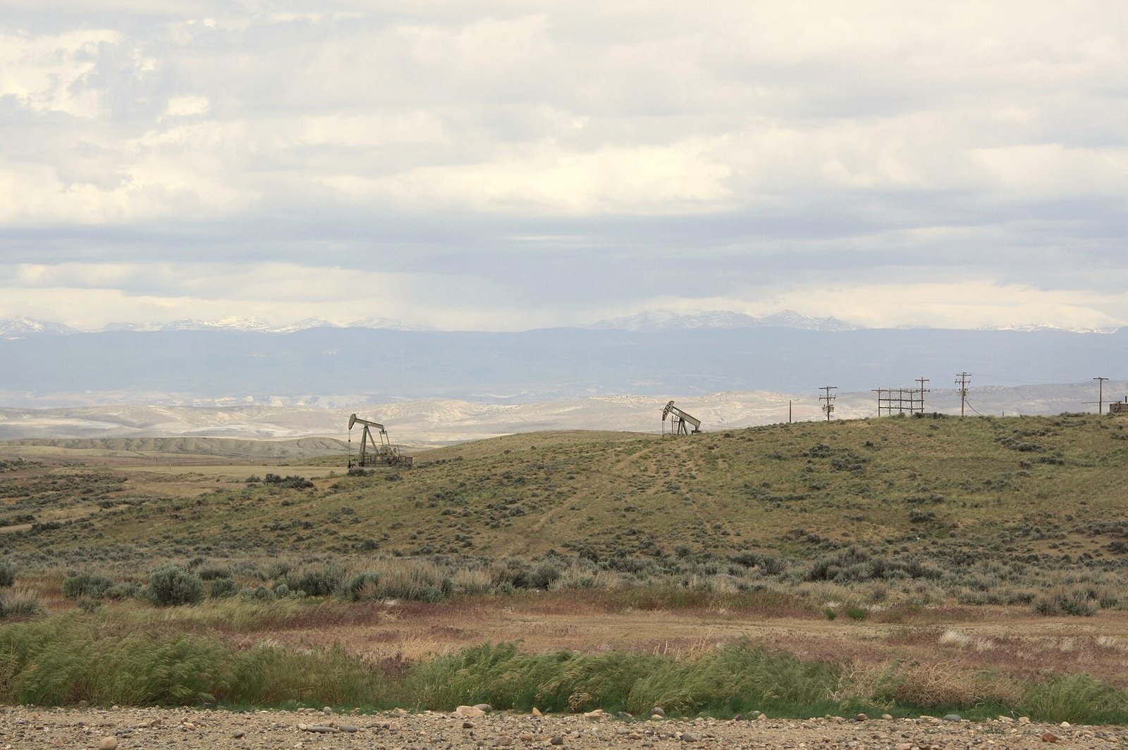 Pump jacks spread across open sagebrush country